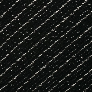 Close-up of black and white tweed knit texture on a stylish two-piece women's suit set