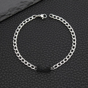 Macro shot of silver stainless steel Cuban chain bracelet with Always engraved bar
