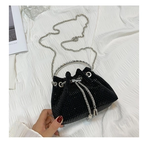 Close-up of black rhinestone bucket bag with silver chain and metal ring handle