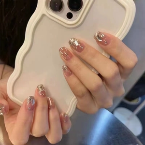 Handgemaakte aurora glitter plaknagels met zilveren steentjes en nude roze basis