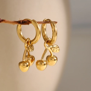 Boucles d'oreilles cerises en acier inoxydable doré 18 carats sur une petite branche