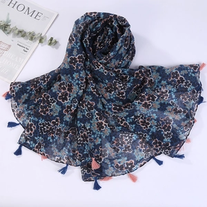 Close-up of blue floral print linen scarf with delicate fringe tassels and soft texture
