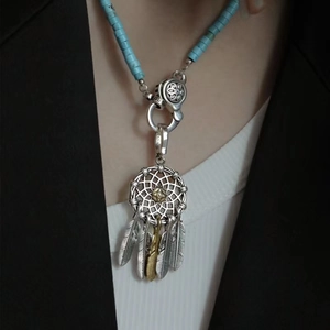 Two-tone dreamcatcher necklace with silver and gold feather pendants on blue beads