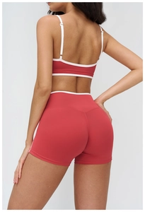 Detail showing back view of dark red sports bra and high-waisted shorts with white piping