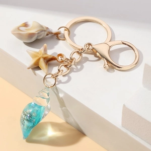 Detail of marine keychain with starfish and resin shell on geometric background