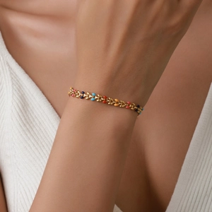 Bracelet feuilles en acier doré avec breloques émaillées colorées au poignet