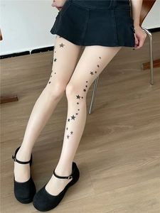 Detail of sheer star-printed pantyhose in beige skin tone with black star patterns