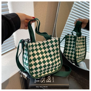 Close-up of green and white checkerboard woven handbag with adjustable shoulder strap