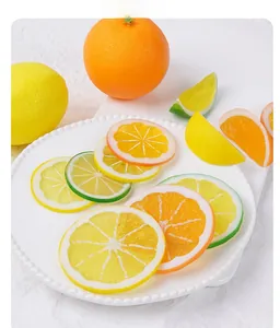Detailed view of realistic PVC lemon and orange slices on a white textured background
