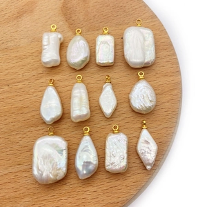 Macro view of assorted baroque freshwater pearl pendants with golden metal eyelets