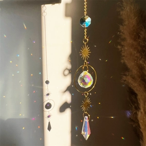 Golden crystal suncatcher with moon and star prisms reflecting colorful sunlight