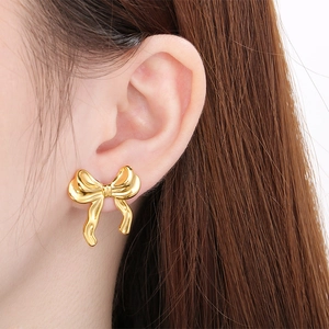 Gros plan sur une boucle d'oreille papillon dorée portée montrant les détails fins