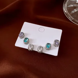 Three pairs of halo oval zircon stud earrings in lavender, blue, and clear white tones