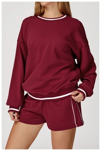 Détail d'un ensemble sweat bordeaux avec rayures contrastées blanches au col et aux poignets