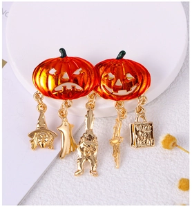 Detail view of orange pumpkin brooches with gold pendants and Trick or Treat lettering