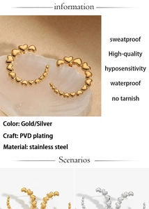 Detailed macro view of C-shaped stainless steel heart earrings in gold and silver finish