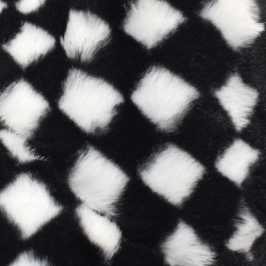 Macro detail of the plush black and white checkerboard faux fur texture on the bucket hat