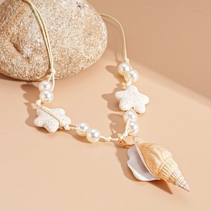 Detail of seashell and starfish charms on a pearl beaded necklace with natural stone background