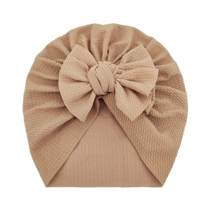 Detailed texture of khaki waffle knit baby hat featuring a large soft bow knot