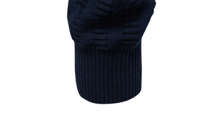 Detailed close-up of dark blue knit fabric with ribbed cuff on men's half-zip sweater