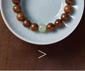 Macro shot of Golden Sandalwood prayer beads on a green cracked ceramic plate