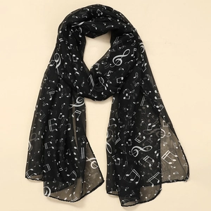 Detail of sheer chiffon scarf showing white musical note prints on black fabric
