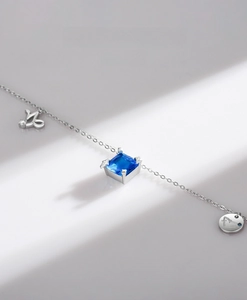 Detail of S925 silver Capricorn necklace with a square blue crystal and zodiac pendant