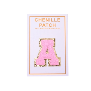 Detail of pink chenille letter A patch with gold glitter edge and peel-and-stick backing