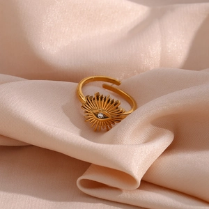 Detailed macro view of gold 18k evil eye sunburst ring with zircon on silk fabric