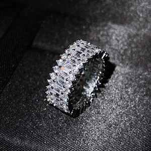 Detailed close-up of triple-row silver ring with baguette and round cut zircons