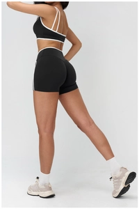Detail view of high-elastic black yoga set with white trim showing slim fit and lift