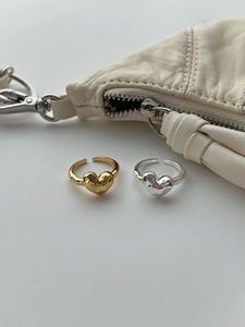 Close-up of gold and silver S925 heart rings with adjustable bands and textured finish