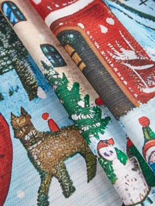 Close-up of linen-textured Christmas tablecloth with festive elk and snowman patterns