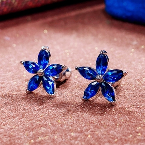 Macro shot of navy blue zircon flower stud earrings with marquise petals on silver base