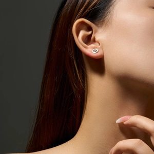 Macro side view of 925 silver round earring featuring a tiny heart-shaped diamond inlay