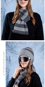 Dettaglio del set cappello e sciarpa in maglia grigia a righe con fiocchi di neve