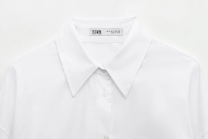 Detail of white shirt lapel collar with clean stitching and minimalist textile texture