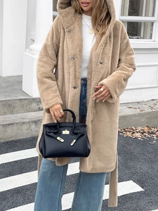 Détail d'un élégant manteau beige à capuche en fausse fourrure avec ceinture à la taille