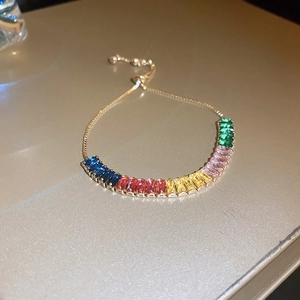Détail d'un bracelet doré réglable avec cristaux baguette arc-en-ciel et fermoir coulissant