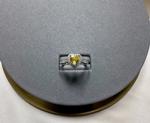 Detailed top view of 6mm heart-cut yellow diamond silver ring with halo setting