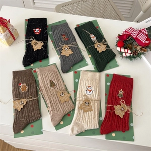 Detail of Christmas crew socks set with holiday embroidery and festive gift packaging