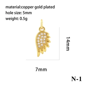 Macro detail of 14mm copper gold plated angel wing pendant with inlaid cubic zirconia