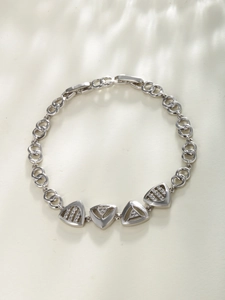 Macro detail of silver geometric triangle link bracelet with sparkling zircon stones