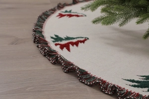 Detail of knitted Christmas tree skirt with festive red green tassels and 3D cedar pattern