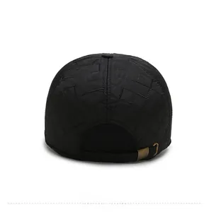 Close-up of black quilted hat showing adjustable bronze buckle and quilted fabric texture