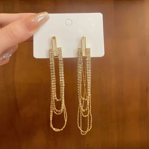 Detail of long layered tassel earrings in gold finish with sparkling rhinestones