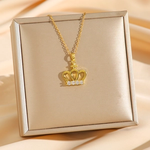 Golden crown pendant necklace with zircons on silk background for elegant jewelry display