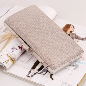 Detail view of champagne glitter clutch with silver metallic frame and top snap closure