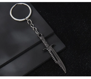 Close-up of gunmetal alloy military knife keychain with Cross Fire engraving detail