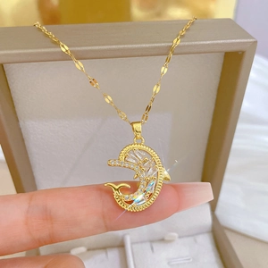 Close-up of golden dolphin pendant with sparkling zircon inlay on flat link chain